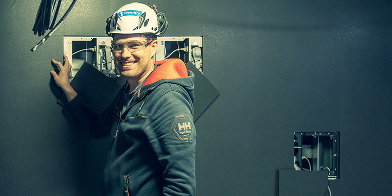 ZetaDisplay technician wearing a Pronto VT hard hat and safety glasses, installing an LED display panel